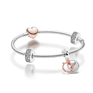 silver plated bracelet band with clear crystal gemstone stoppers, a "Queen" engraved silver charm and rose gold heart shaped clasp