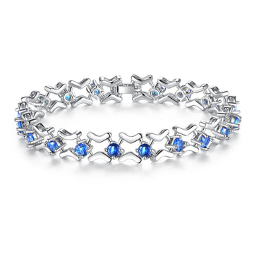 Rhodium-plated silver toned link bracelet featuring blue simulated sapphire gemstones and a subtle elegant clasp