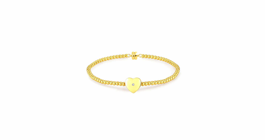 yellow gold plated bracelet featuring a natural diamond within a single heart-shaped accent charm.